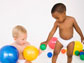 two young children playing with balls