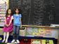 two girls in front of a chalk board