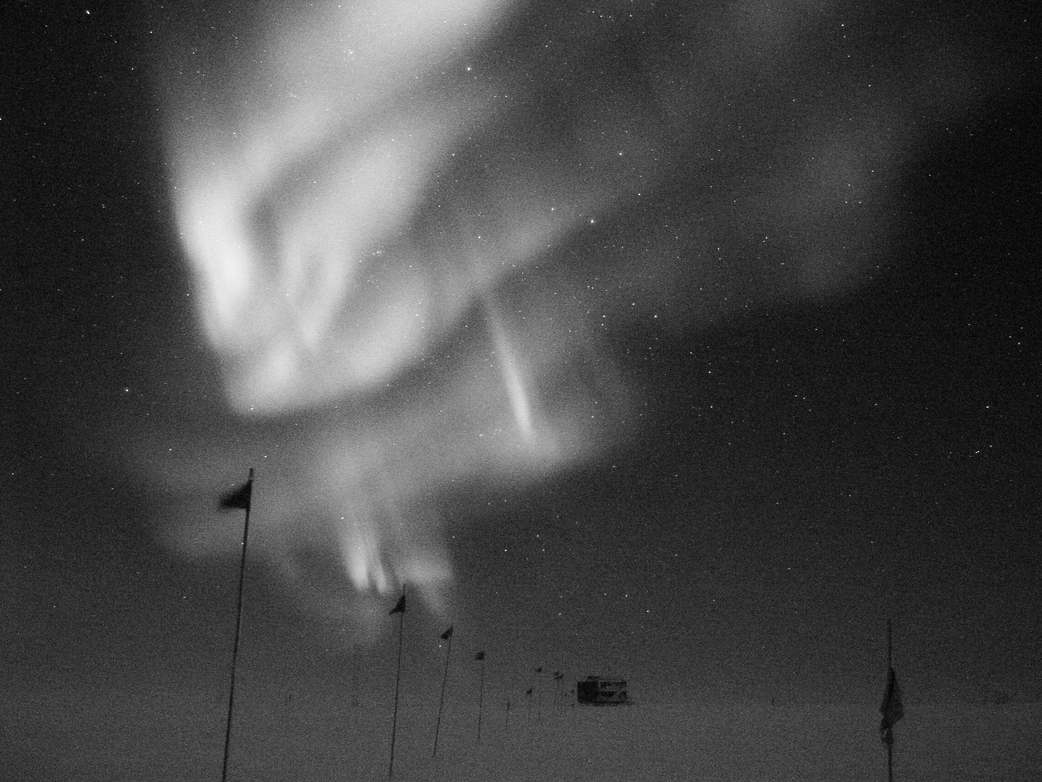 Southern Lights, over the flagline to a building at NSF's Amundsen-Scott South Pole Station; caption is below