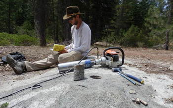 researcher with a gas-powered, water-cooled drill for sampling bedrock