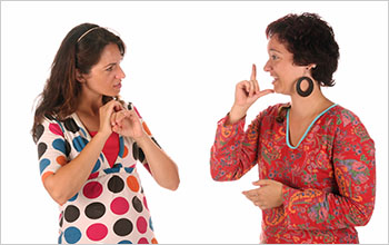 Two women communicate using sign language.