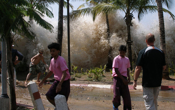 People running away from a tsunami-caused wave