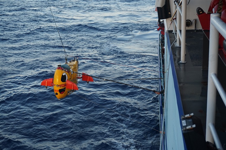 The autonomous underwater vehicle Sentry lowered from a research ship; it will explore deep reefs.