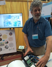 researcher showing a sensing device at an exhibition
