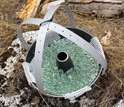 Close-up of a dust collector: pan, mesh, marbles and straps to keep birds from perching.