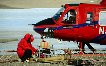 An engineer with AEM sensor next to helicopter