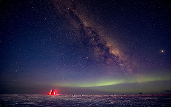 Aurora australis and Milky Way over IceCube laboratory
