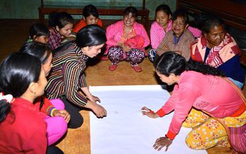 women drawing a map at a community gathering