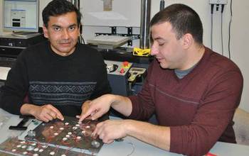 Two people in a lab looking at circuits