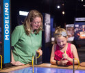children and adult looking at museum exhibit