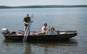 Two scientists in a boat take water samples from Trout Lake in northern Wisconsin.