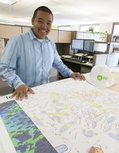A Summer Bridge student  in an office looking at a map