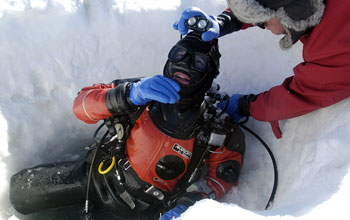Diver prepares to leave dive hole into McMurdo Sound, Antarctica