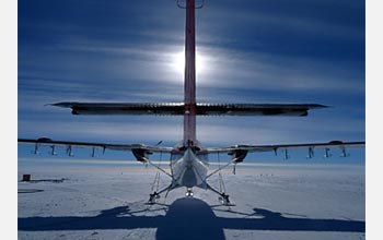 Photo of a Twin Otter aircraft silhouetted by the sun.
