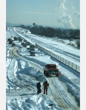 Photo of automobiles stuck on a highway during a snow storm.