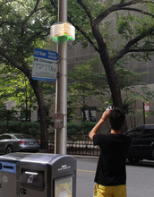 Artist rendering of man taking photo of an Array of Things node mounted on city streetlight pole