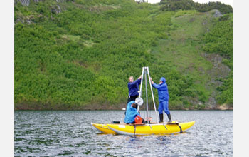 Photo of researchers taking a sediment core from a lake in Alaska.