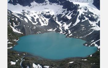 Photo of sharp-crested ridges of glacial debris that descend into Upper Greyling lake in Alaska.