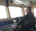 Capt. Dan Hobbs in front of operating controls of the ship