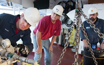 Photo of scientists pre-testing equipment before a vertical seismic profiling experiment.