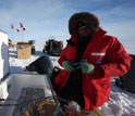 Photo of Slawek Tulaczyk installing a precision GPS sensor for monitoring a subglacial lake.