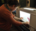 Researcher Clare Loughran takes a digital photo of a red seaweed using a special light box.