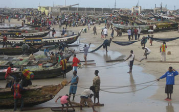 Photo of African fishermen with their boats on the beach.