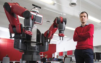 Photo of Matei Ciocarlie standing next to a robot