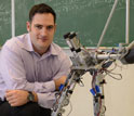 AMBER Lab Head Aaron Ames pictured with two-legged, humanlike robot