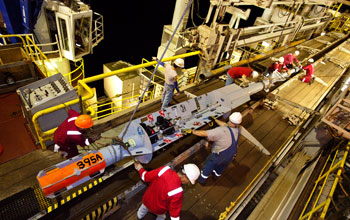 Photo of several crew members prepping an instrument that will remain under the sea-floor.