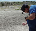 Photo of a scientist inspecting a find in Como Bluff Quarry sediments.