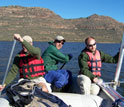 Photo of Brian Chase holding a core, Christiann King paddling and Curt Stager steering.