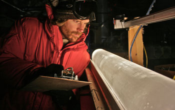 Scientist looking at an ice core from the West Antarctic Ice Sheet Divide coring site.