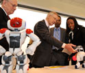 Photo of Sen. Reid interacting with soccer robot dogs.