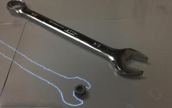 metal wrench next to electronic outline of a wrench