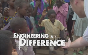 Man holding out his hand to children with the words Engineering a Difference