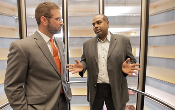 two men talking in an elevator