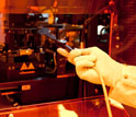 Photo of a researcher loading a template for nano-sculpting on plastic films in a roll-to-roll tool.