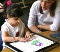 A kindergartner examines a Talking Tactile Tablet picture of a flower.
