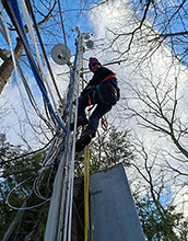 Scientist Daniel Obrist climbs a tower in Harvard Forest to measure mercury deposition.