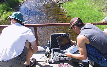 photo of two researchers near a stream