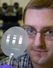 Doctoral student displays a disk containing several "micro-pump" cooling devices