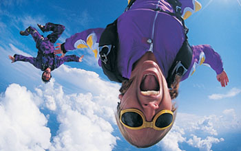 Photo of two young adults skydiving.
