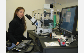 Photo of Susannah Gordon-Messer working on the fluorescence microscope used for her research.