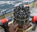 Overhead view of a water-sampling rosette on vessel and researchers
