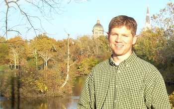Photo of John Rothlisberger standing in front of one of the lakes on Notre Dame's campus.