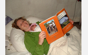 Photo of Starry Sprenkle viewing her first publication with her first child.
