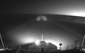 Photo of the lights of Nome, Alaska over the Healy's bow.