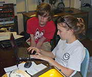Scientists recording data in a lab aboard the research vessel Thompson during a project cruise.