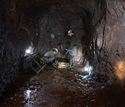 scientists work on a point-of-access sampling device within a mine tunnel